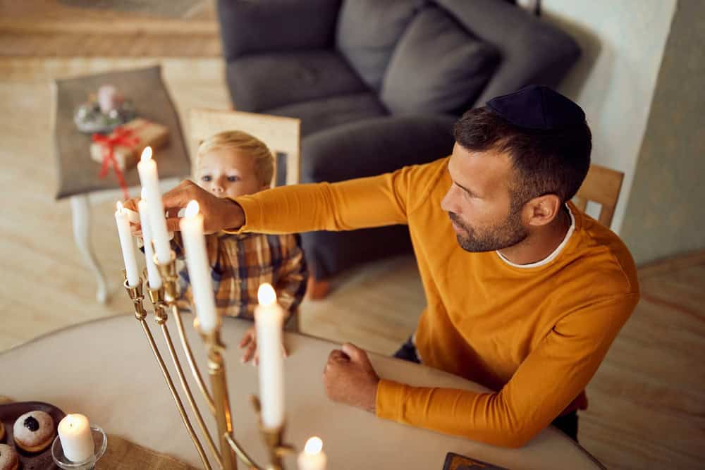 father and son lighting menorah