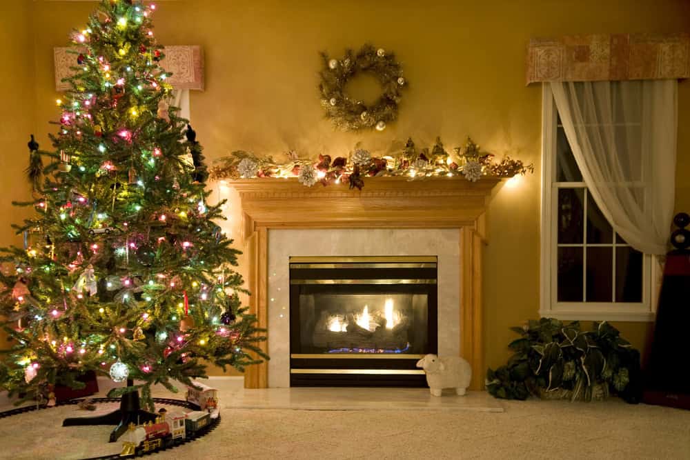 christmas tree in a living room with christmas lights displayed on mantel